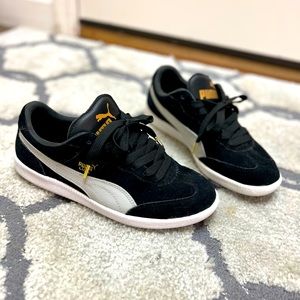 PUMA LIGA, 9.5, Black and gold with golden metal shoelace tips.